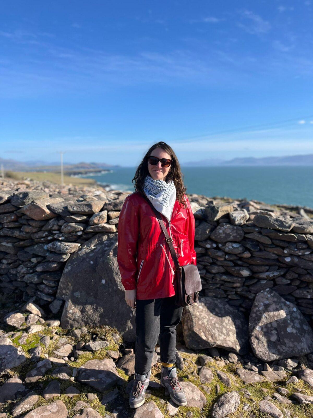 photo of Helen Falvey, stone wall, sea and sky in background