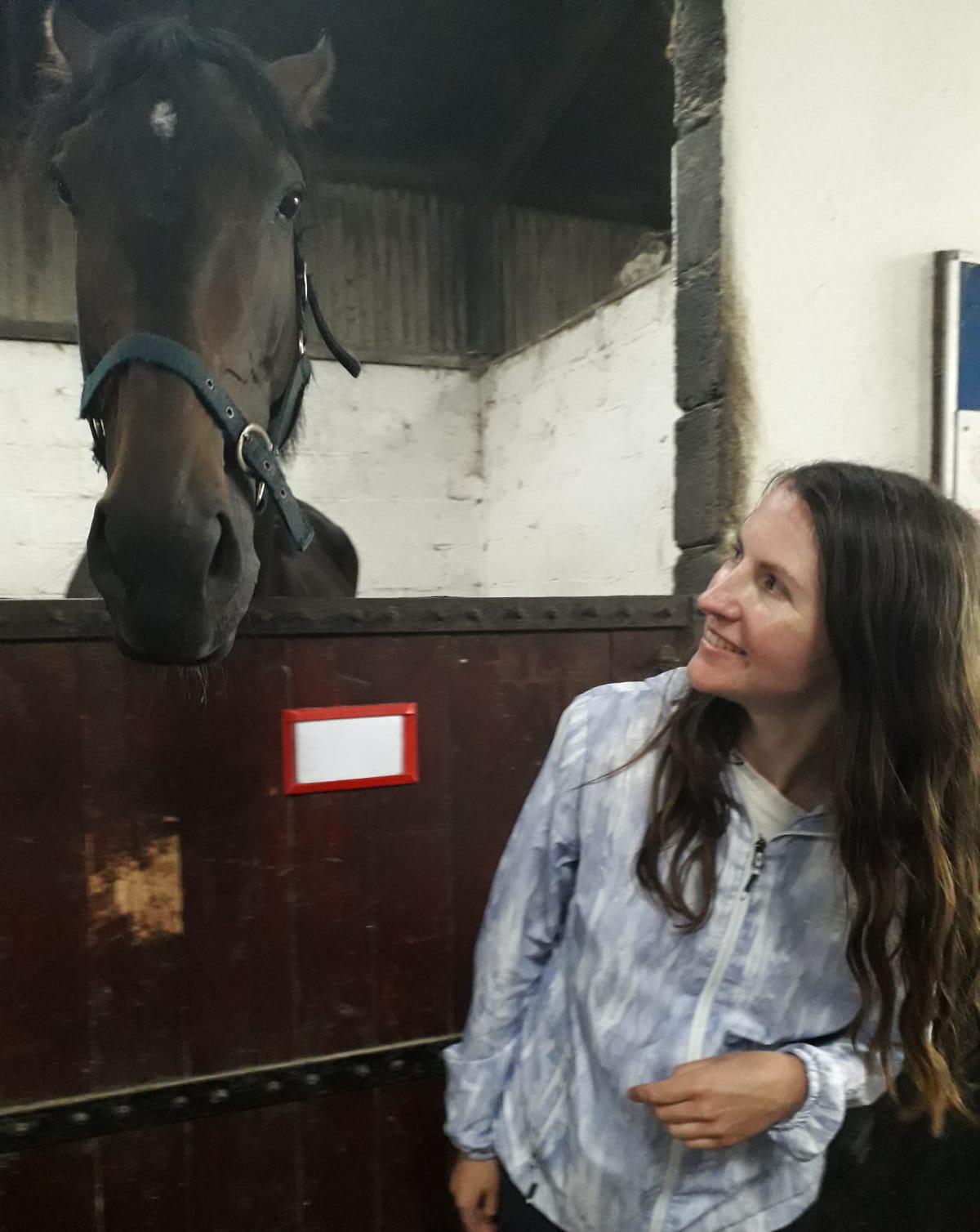 Helen in stables with a dark brown horse
